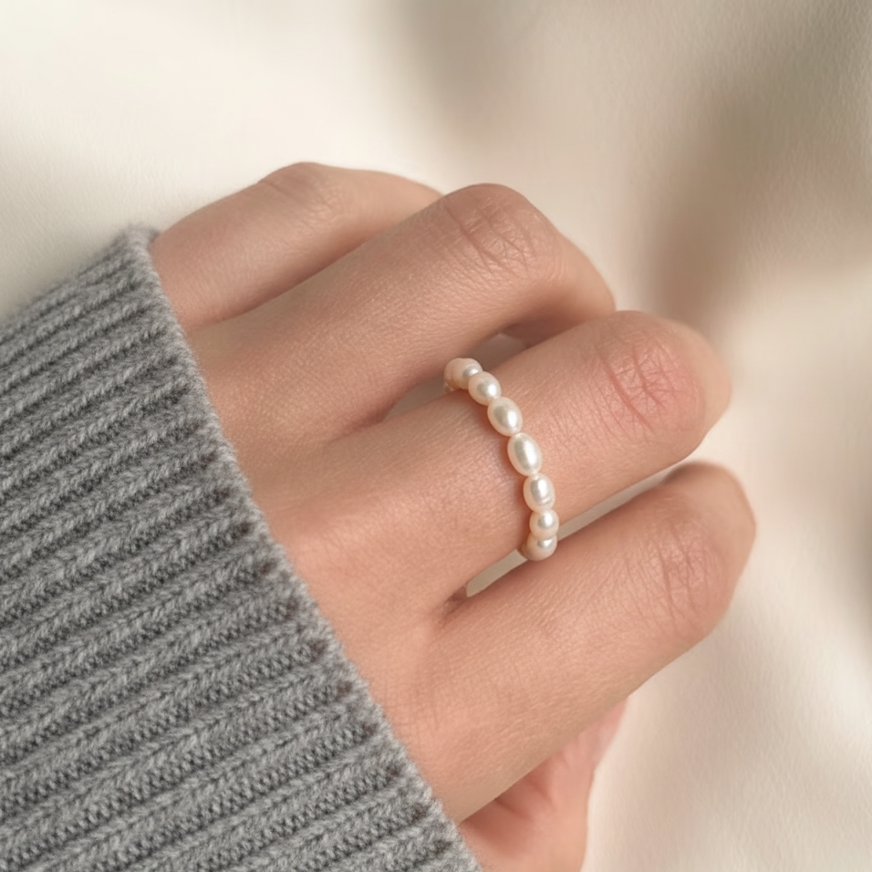 Feiner Ring aus kleinen weißen Süßwasserperlen an der Hand